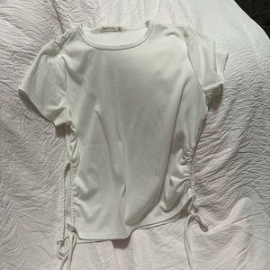 White shirt. Side is open with two strings to tie on the side